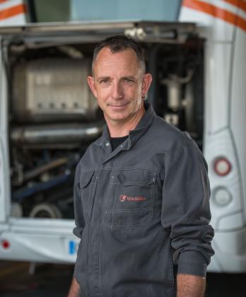 Technicien Transdev devant un bus en maintenance