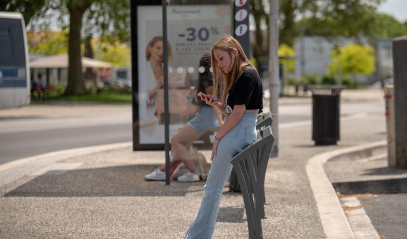 Fille qui attend à un arrêt de bus