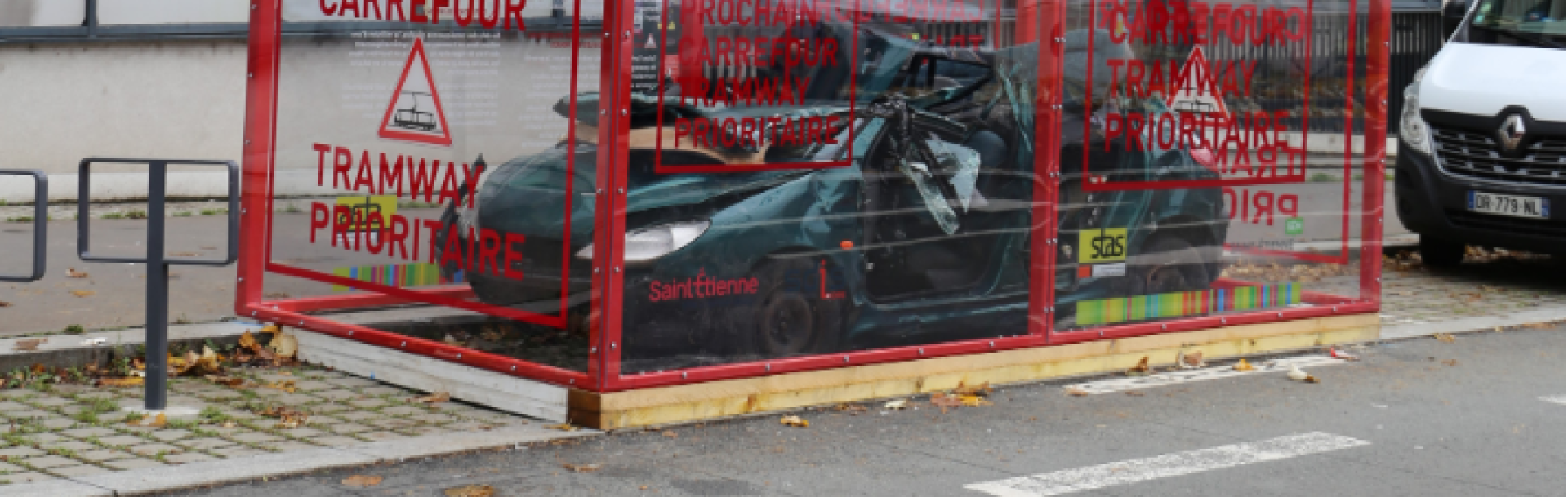 Voiture gravement accidentée exposée dans un cadre de verre sur la voie publique