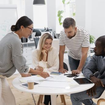 4 personnes autour d'une table en train de réfléchir