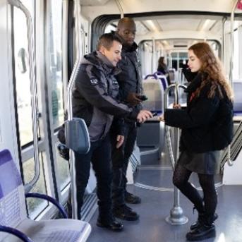 Jeune femme qui se fait contrôler dans un tramway