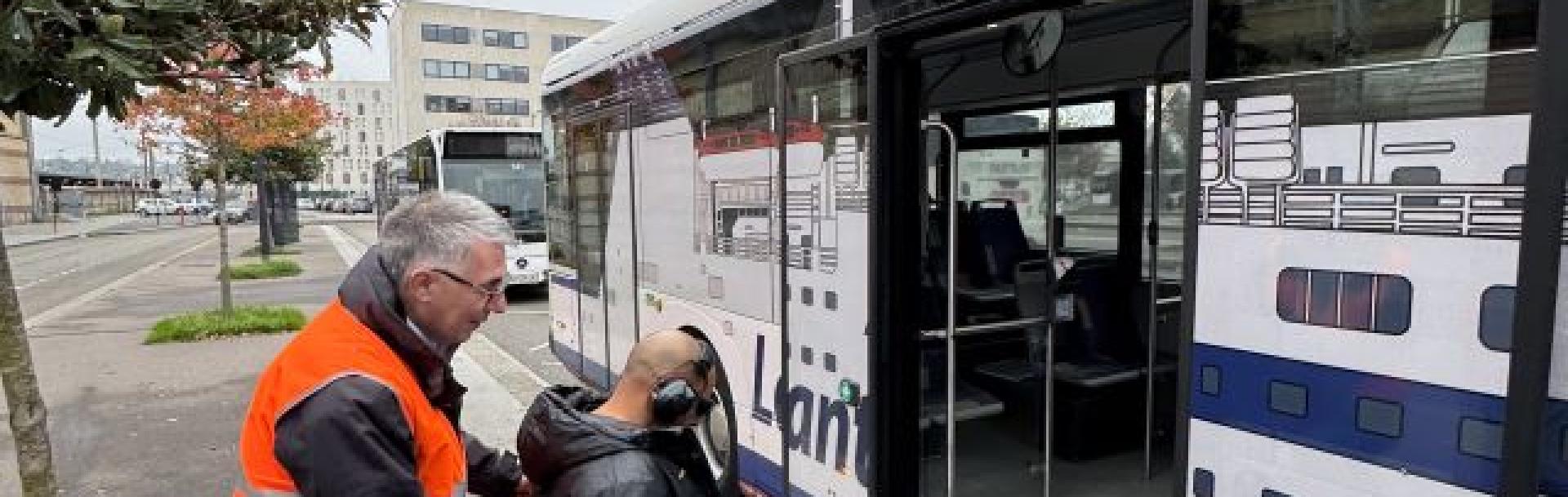 Le Havre - Homme fait monter une personne assise en fauteuil roulant dans un bus LIA