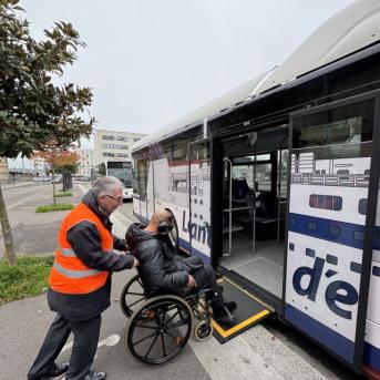 Le Havre - Homme fait monter une personne assise en fauteuil roulant dans un bus LIA