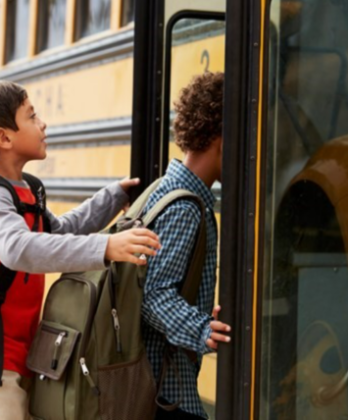 Children getting on a yellow school bus