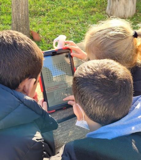 Trois enfant assis devant une tablette