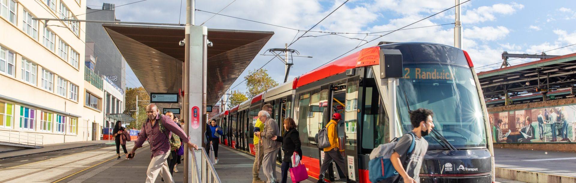 Passagers d'un tramway qui montent et descendent à une station
