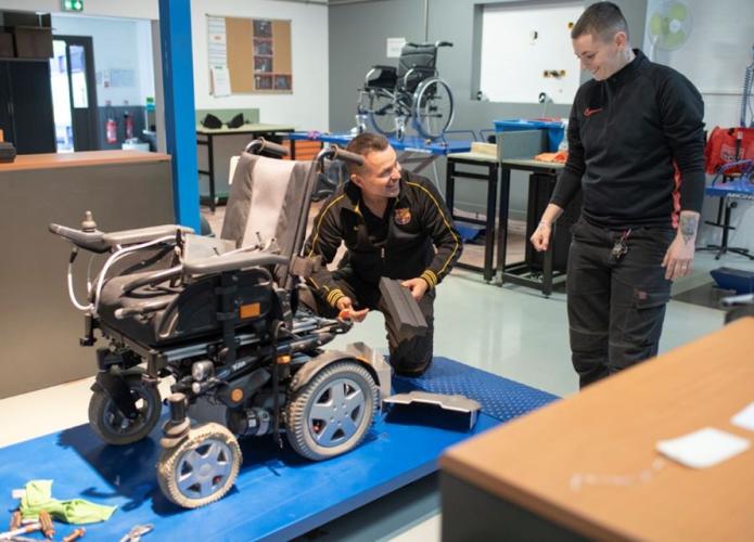 people working on a wheelchair