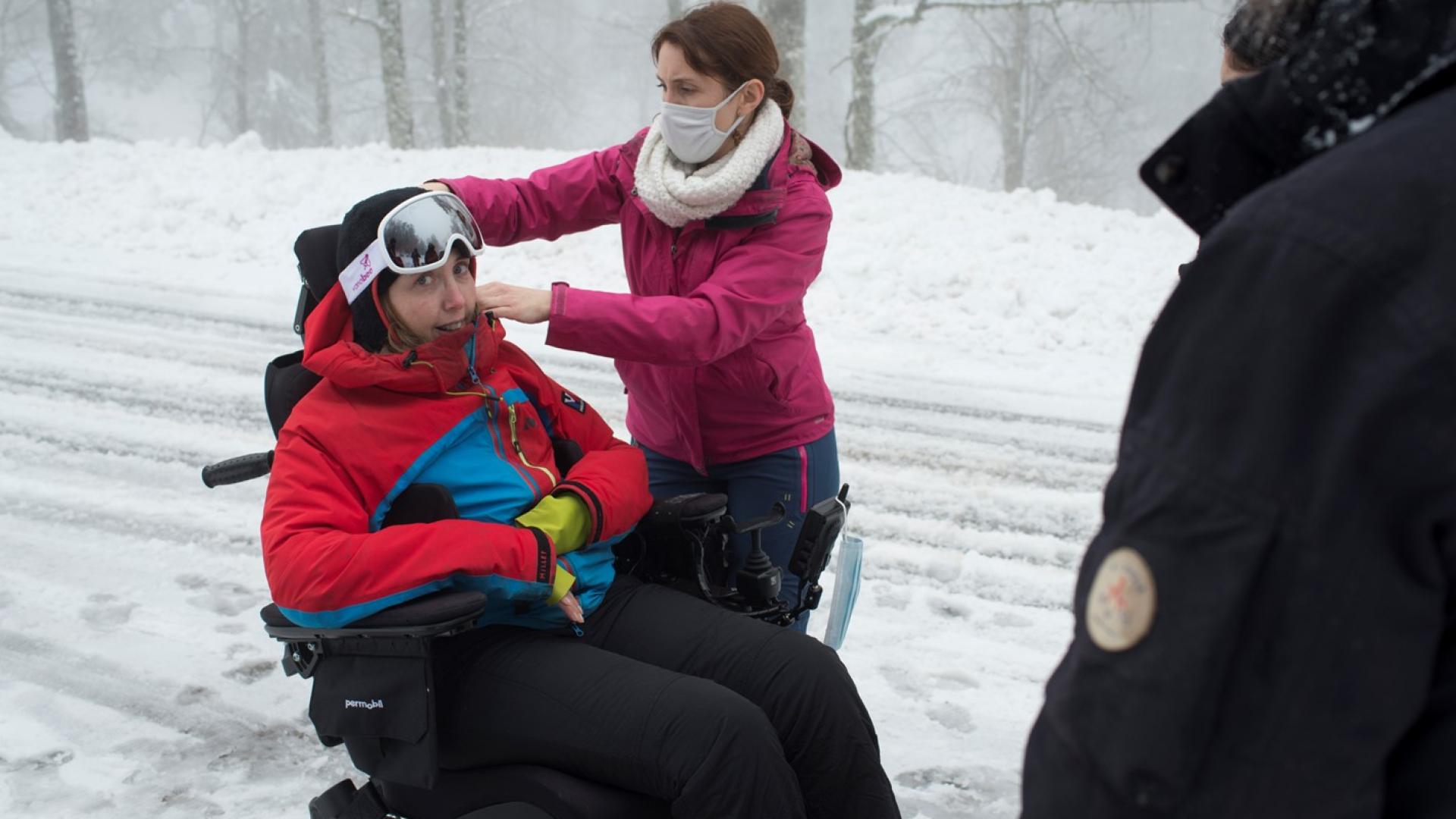 personne dans un fauteuil roulant avec 2 personnes