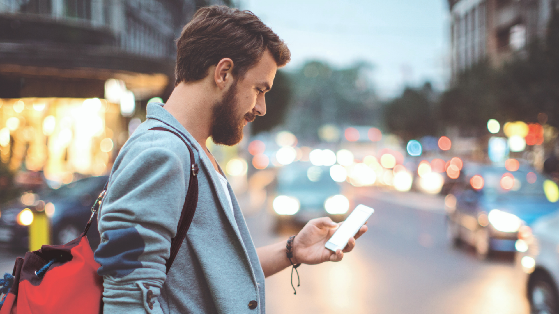 Homme qui regarde son téléphone dans le rue