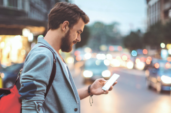 Homme qui regarde son téléphone dans le rue
