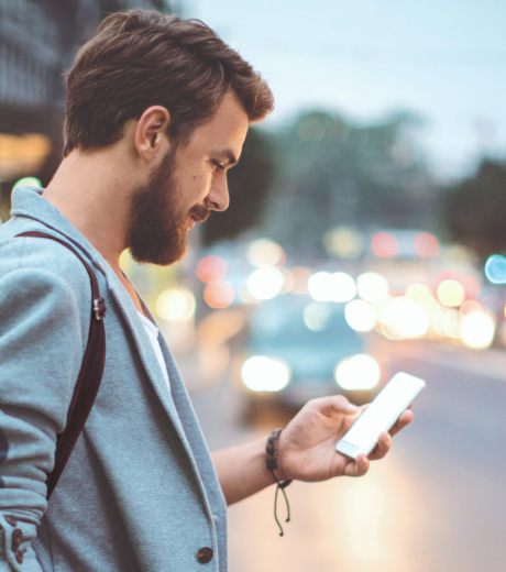 Homme qui regarde son téléphone dans le rue