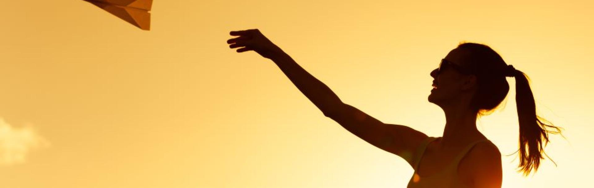 The Mobility Sphere Jeune femme lance un avion en papier - Paper plane