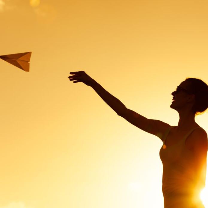The Mobility Sphere Jeune femme lance un avion en papier - Paper plane