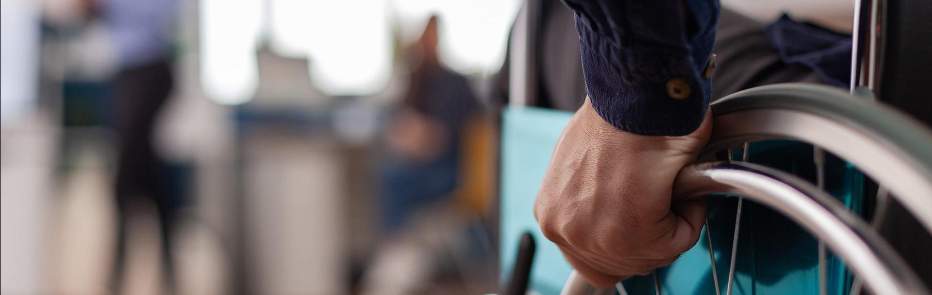 Une personne qui tient la roue de son fauteuil roulant