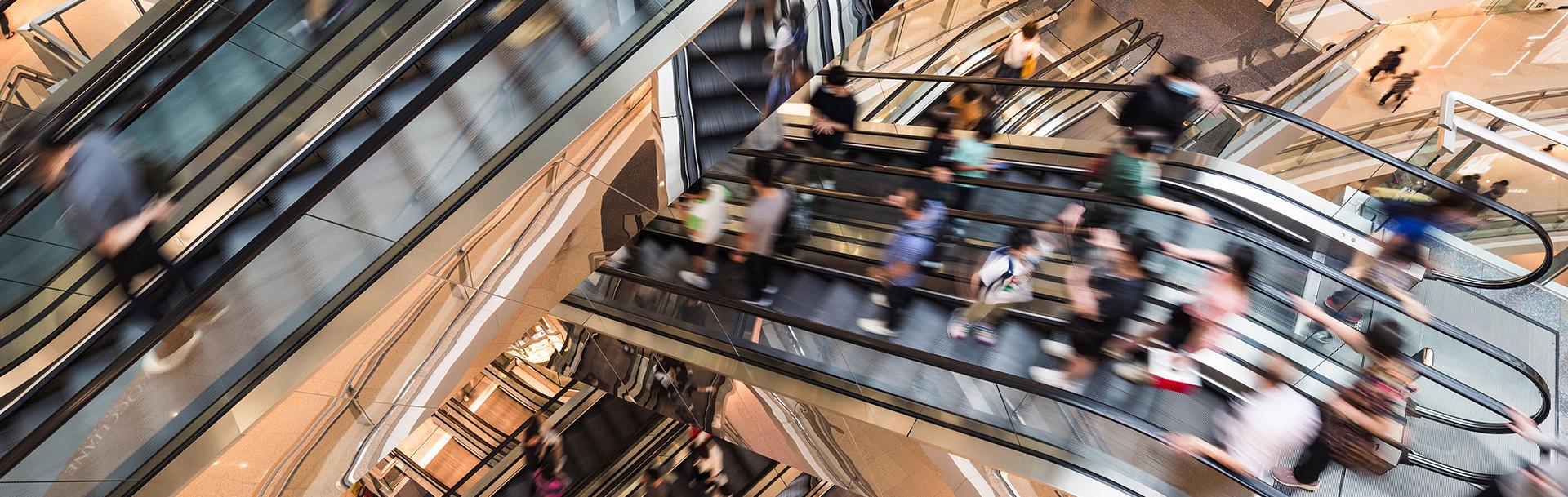 Personnes qui descendent par des escalators