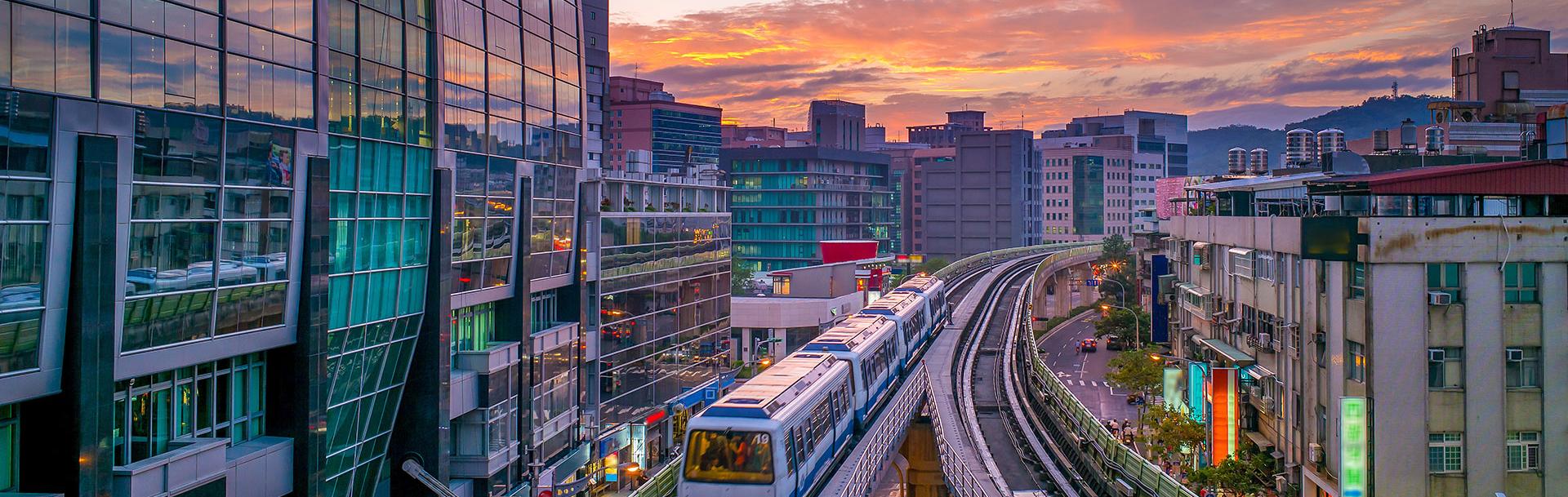 Moving train with buildings and a sunset