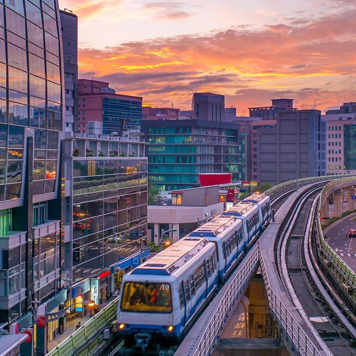 Moving train with buildings and a sunset