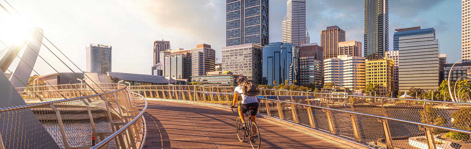 A man biking on a bridge in a city
