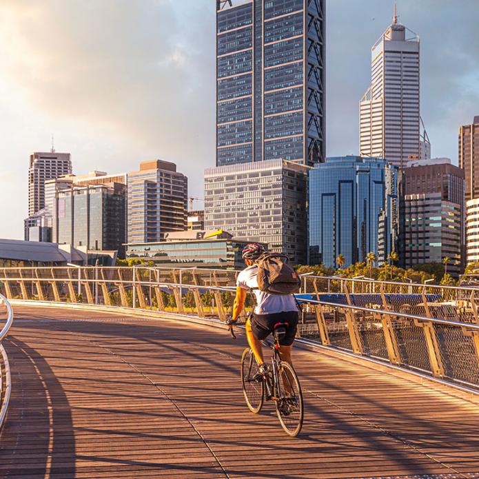A man biking on a bridge in a city