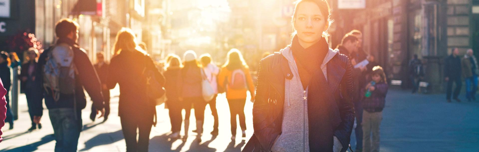A woman walking in the street surrounded by people