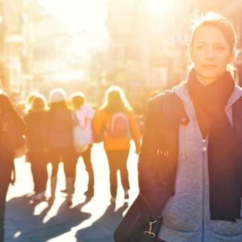 A woman walking in the street surrounded by people