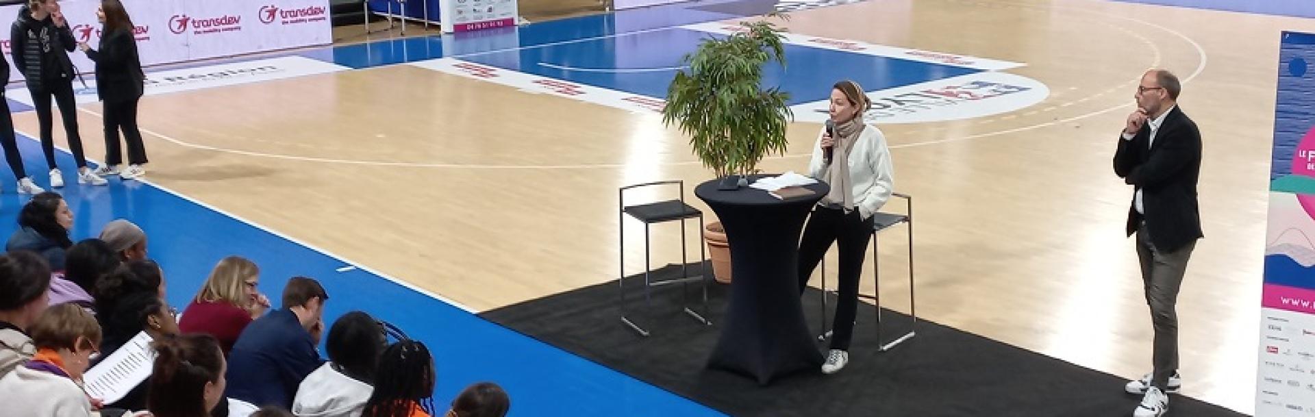 Terrain de basket - Femme au micro assistance sur les gradins- Bannières Transdev autour du terrain