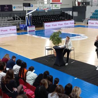 Terrain de basket - Femme au micro assistance sur les gradins- Bannières Transdev autour du terrain