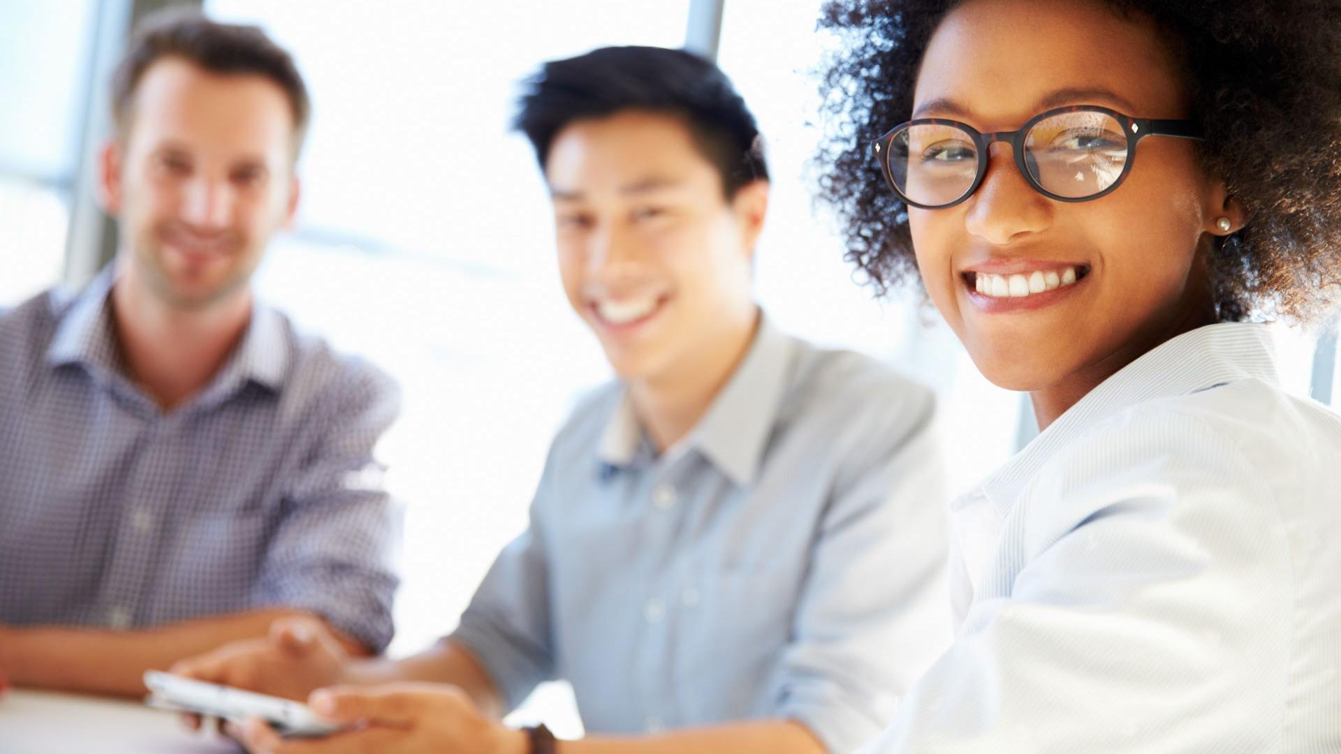 Trois jeunes professionnels souriants travaillent