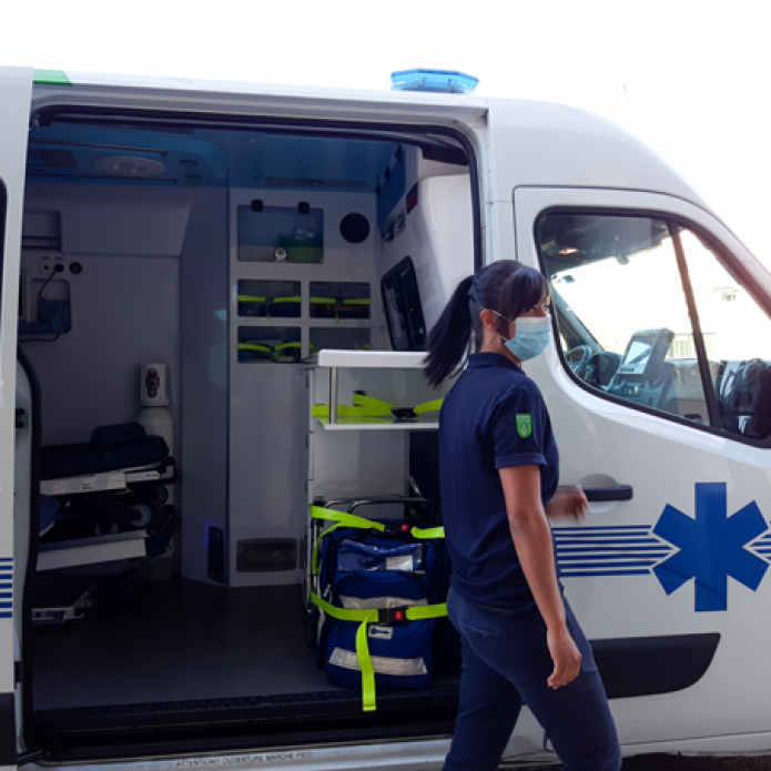Ambulancière qui porte un masque devant une ambulance Carius