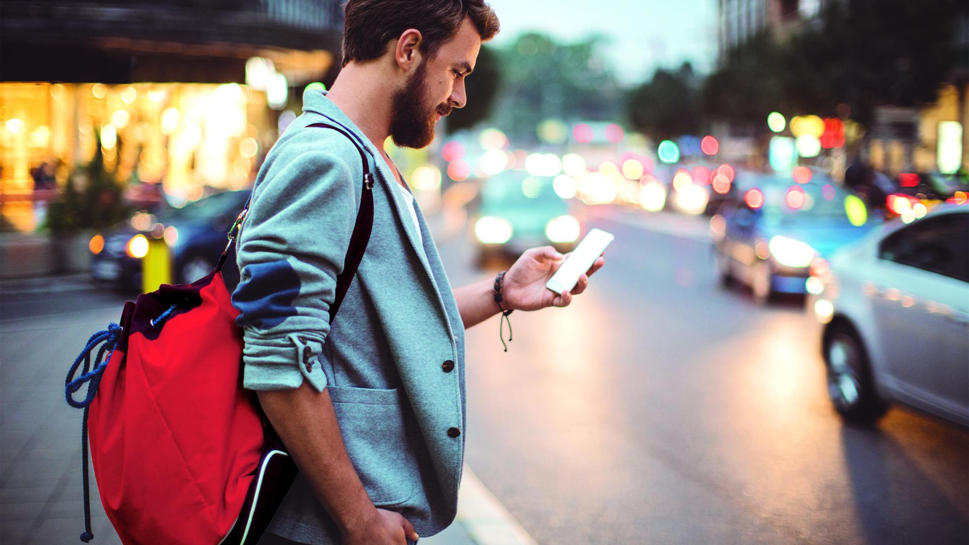jeune homme dans la rue avec un smartphone