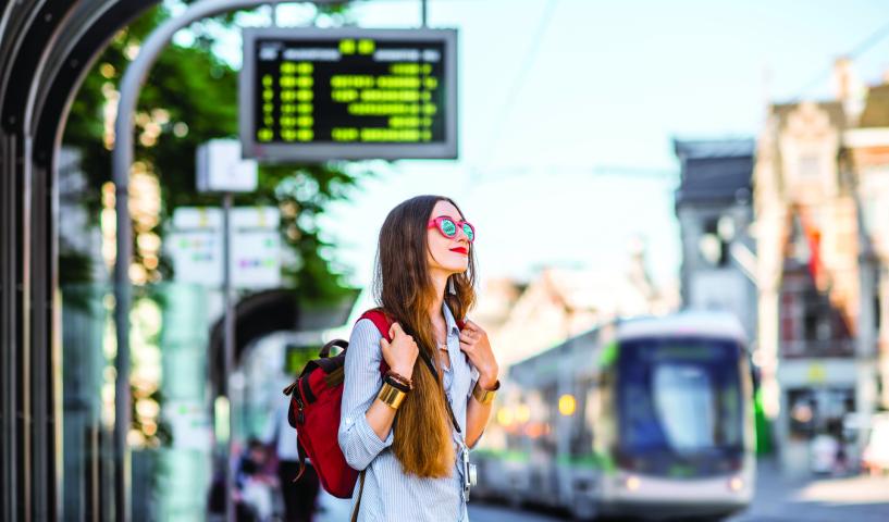 femme à l'arrêt qui attend le tram
