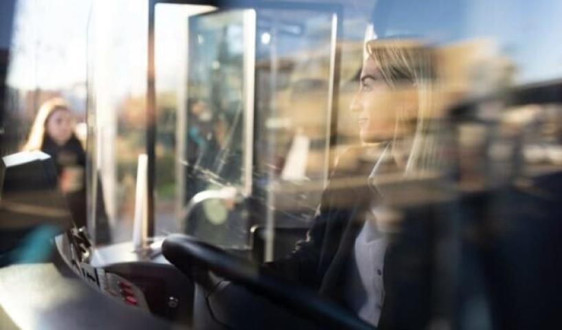 conductrice aux cheveux courts et blonds conduisant un bus