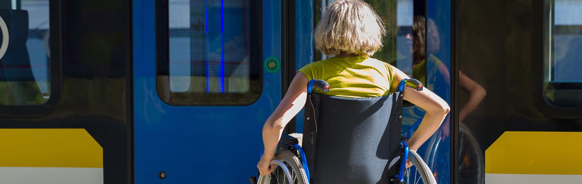 Femme en fauteuil roulant devant un bus