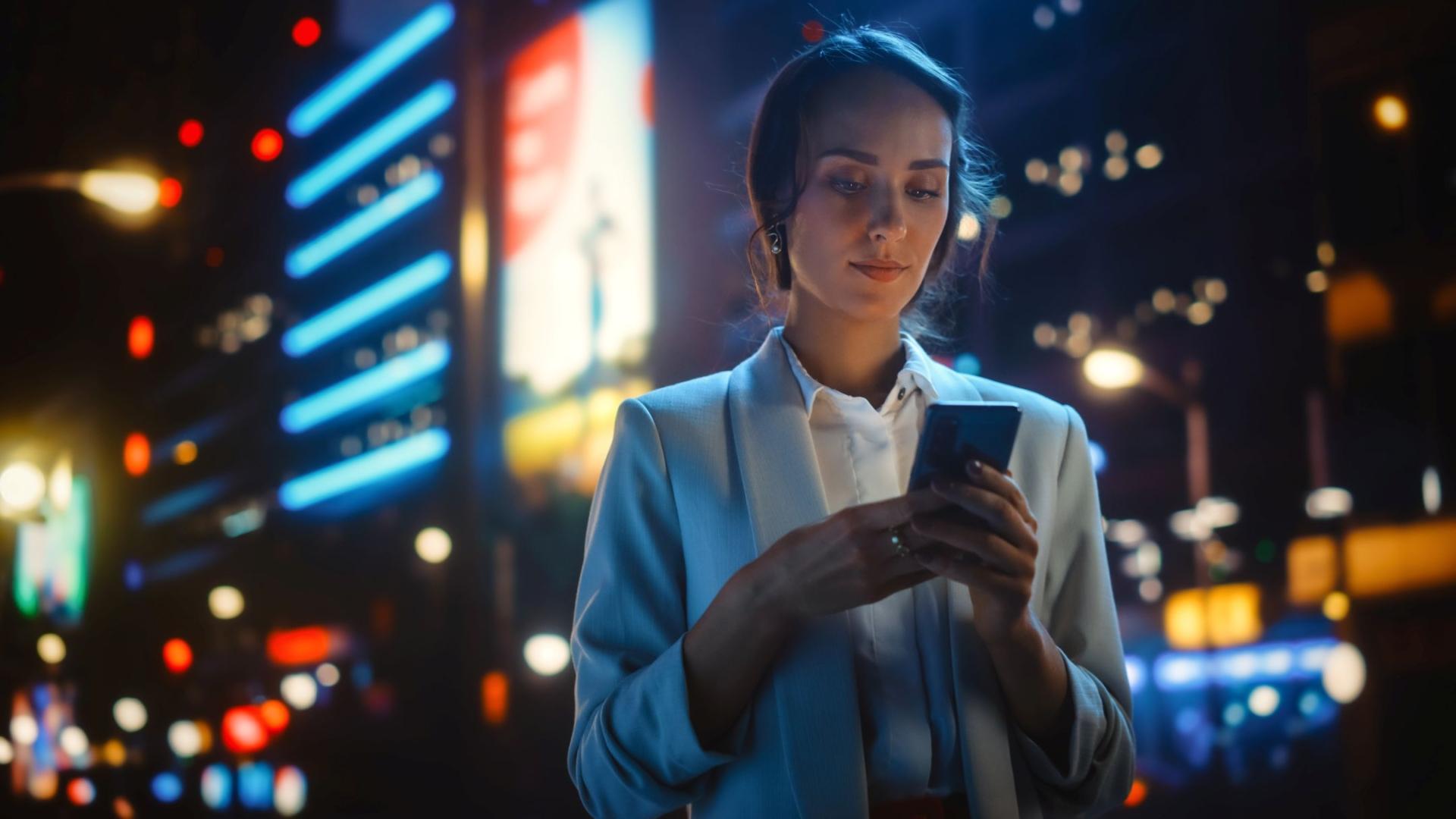 Femme qui utilise un smartphone - ville - nuit