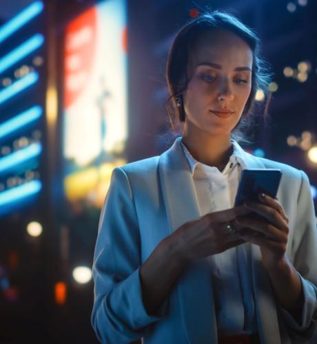 Femme qui utilise un smartphone - ville - nuit