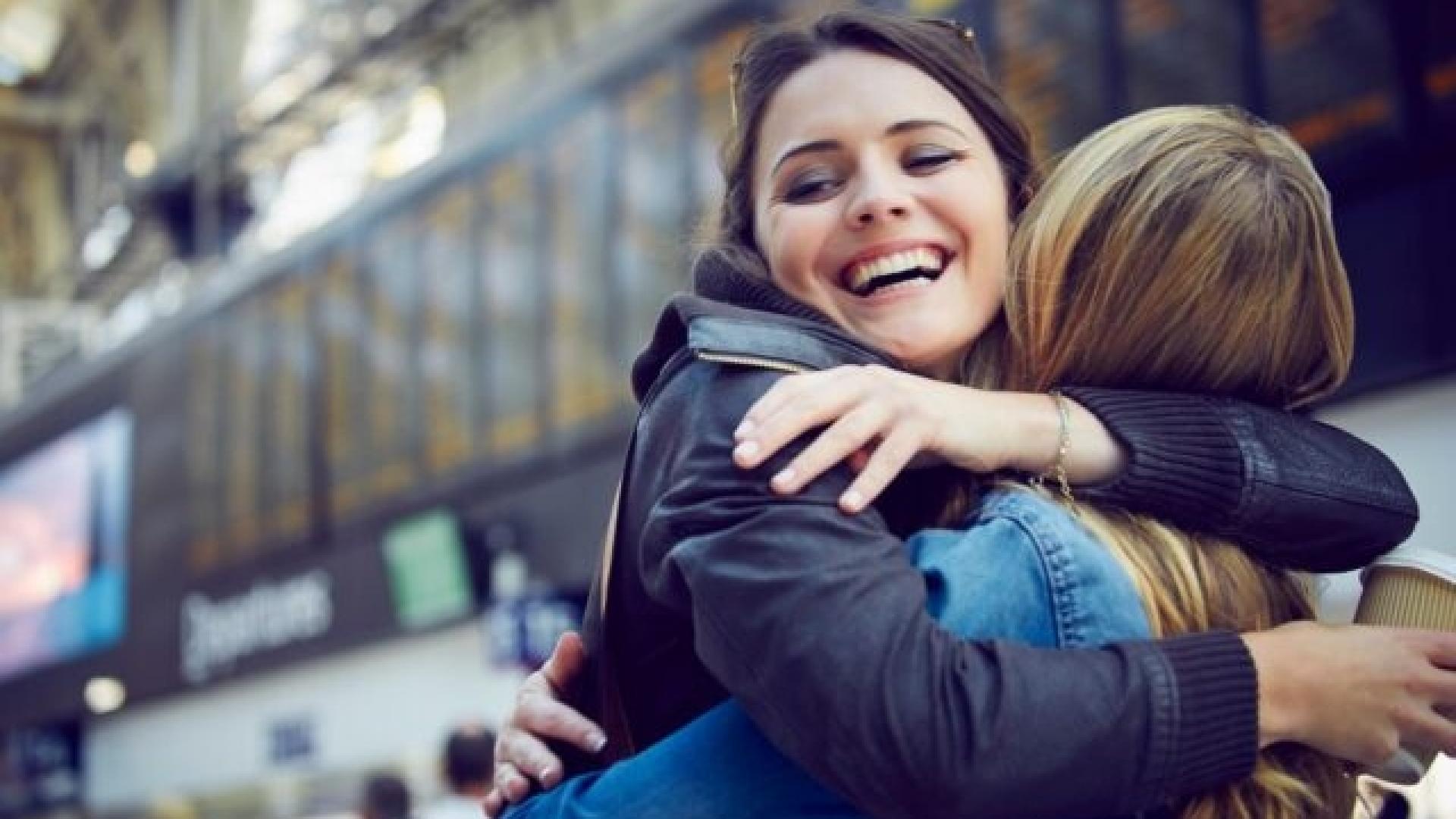 Voyageurs qui s'enlacent dans une gare - Femmes