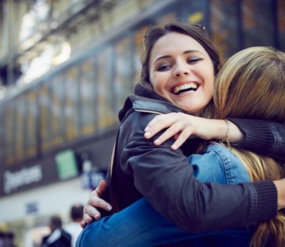 Voyageurs qui s'enlacent dans une gare - Femmes