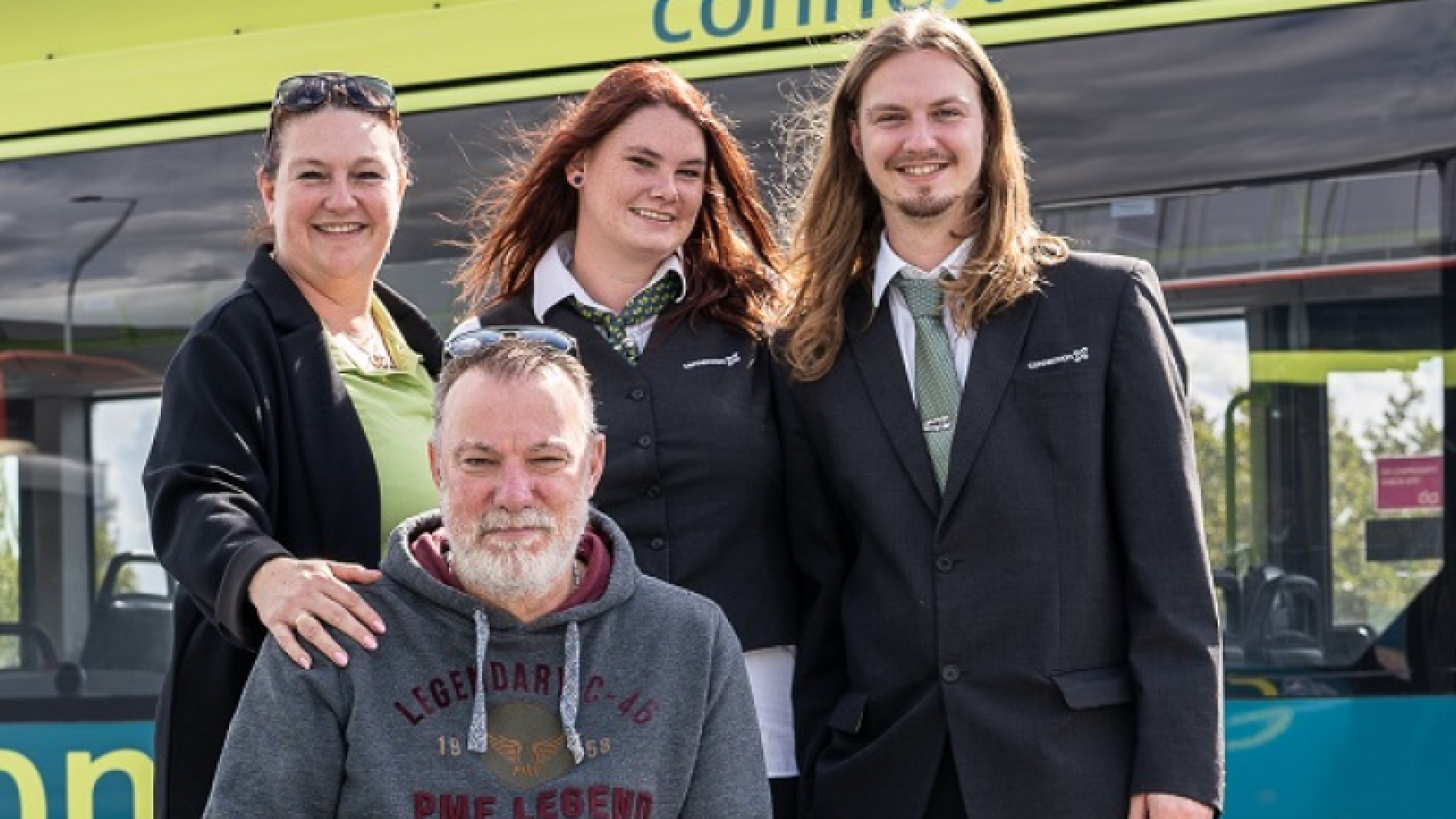 4 personnes devant un bus