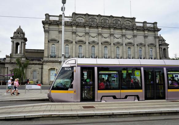 Photo du tramway Luas dans le centre-ville de Dublin, près d'un bâtiment emblématique, symbole de la mobilité durable exploitée par Transdev.