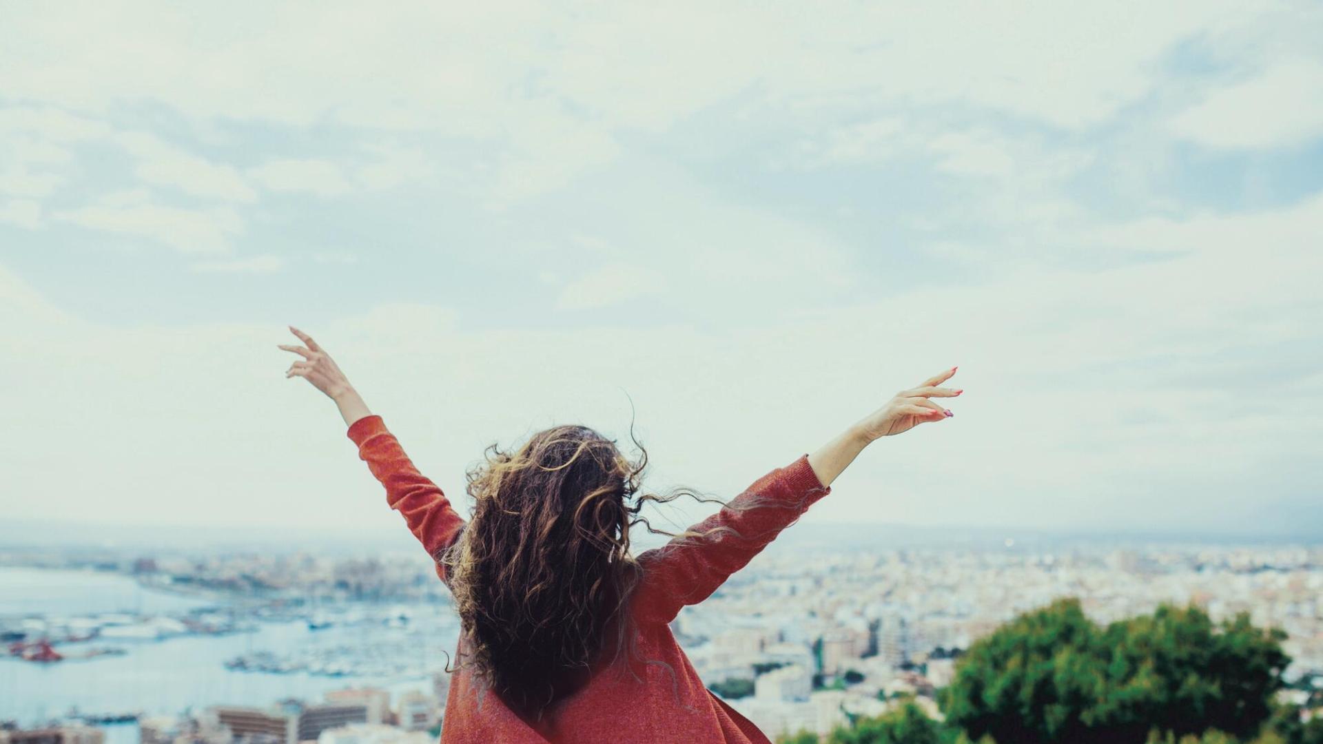 Femme de dos les bras en l'air