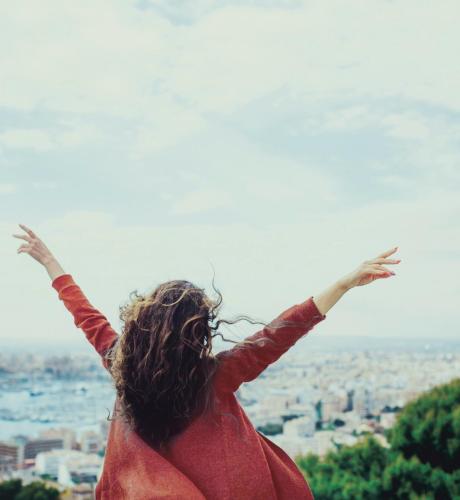 Femme de dos les bras en l'air