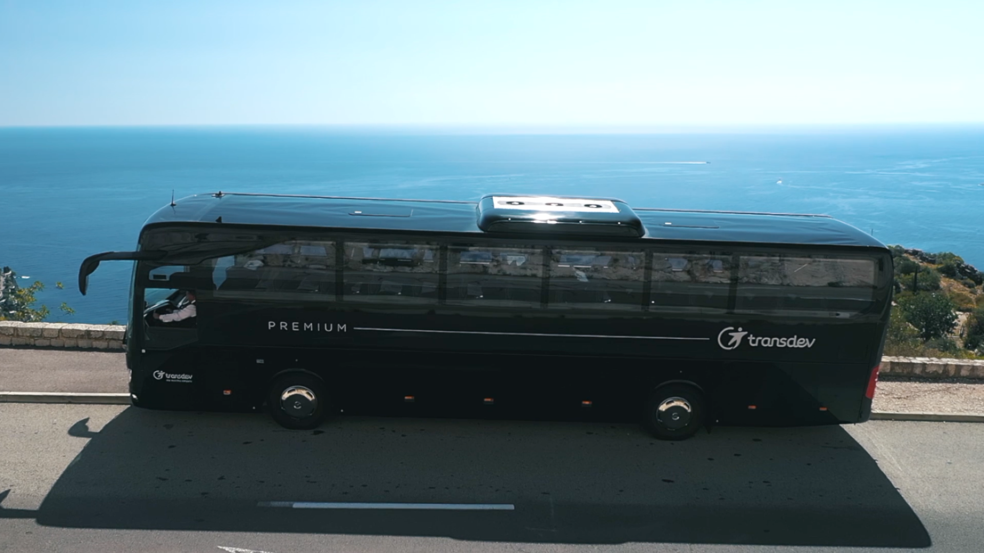 Autocar de tourisme Transdev noir en bord de mer