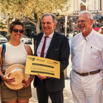 Photo de la cérémonie du 1er anniversaire de l'offre ZOU! Marseille-Toulon-Nice, le 30 juin 2026 : une voyageuse récompensée comme 5 000 000ème passagère pose avec un chèque symbolique, entourée d'élus de la Région Sud, de représentants de l'État, de Transdev et de SNCF Gares & Connexions.