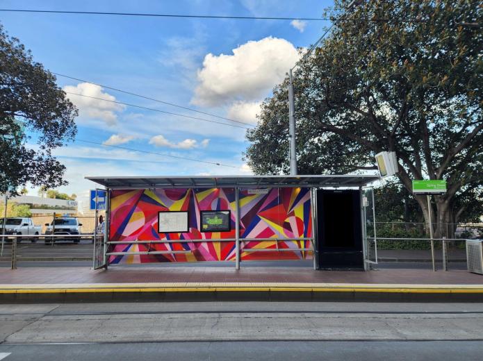 MCG tram shelter at the Richmond Station stop in Melbourne, featuring scenes of cricket and Australian football from Yarra Trams' Art Stops series.