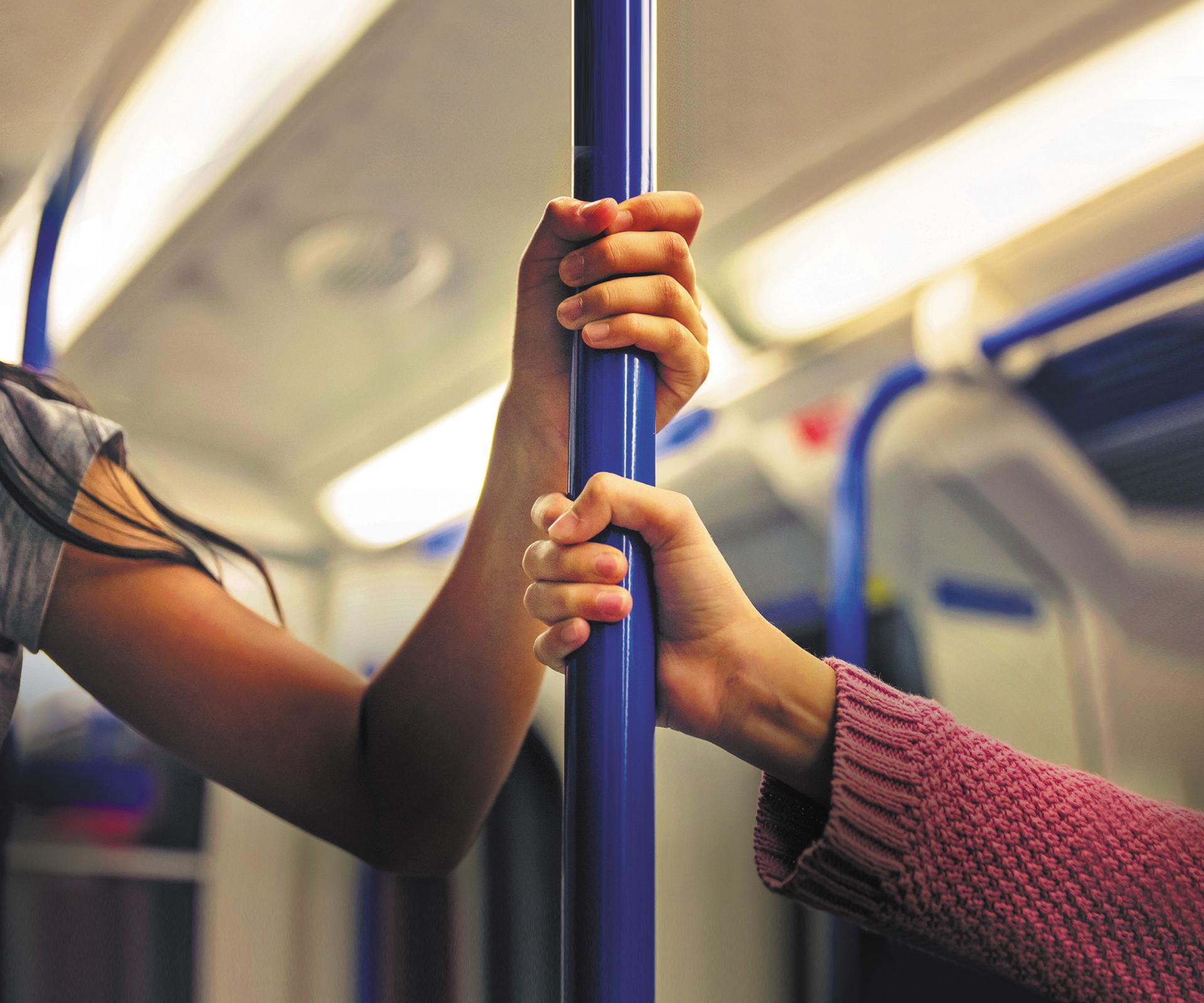 Mains qui tiennent une barre de métro
