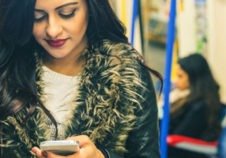 Femme manteau fourrure sur son téléphone dans le métro bleu - Application, solution numérique