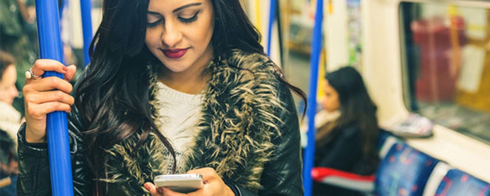 Femme manteau fourrure sur son téléphone dans le métro bleu - Application, solution numérique