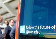 twitter future of mobility transdev sur pare-brise de bus rouge à l'arrêt embarquement