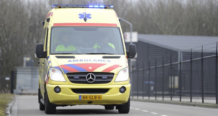 ambulance jaune et rouge en route urgence à côté d'un hangar