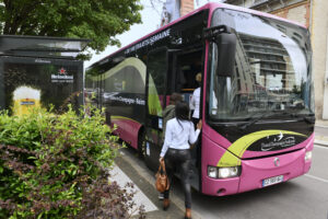 Car rose et vert Trans Champagne Ardennes à un arrêt